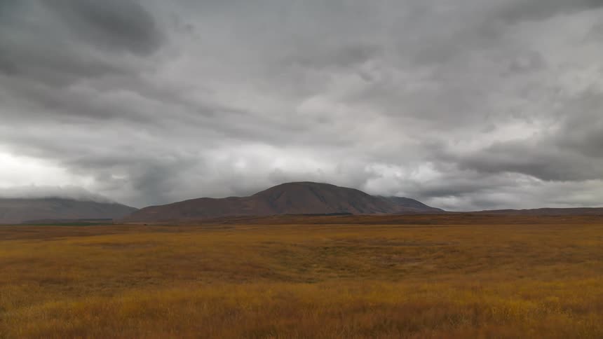 Vast natural countryside with mountains in the background on a cloudy day