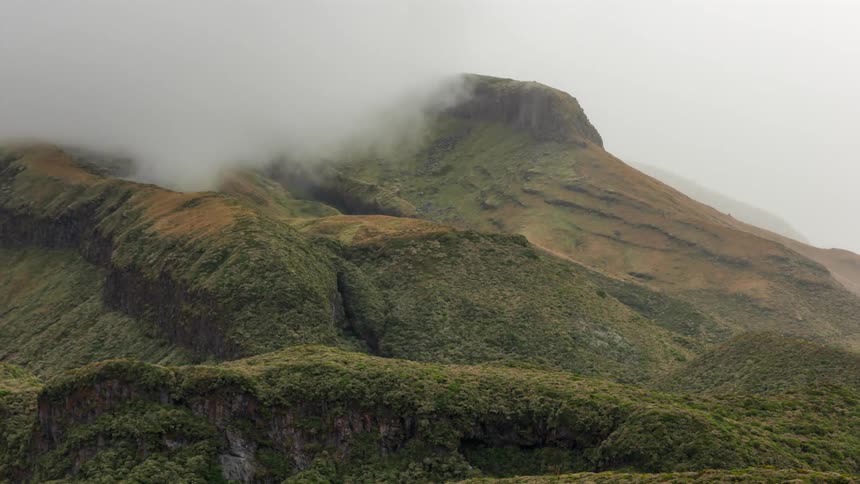Clouds sit on the peak of the mountain