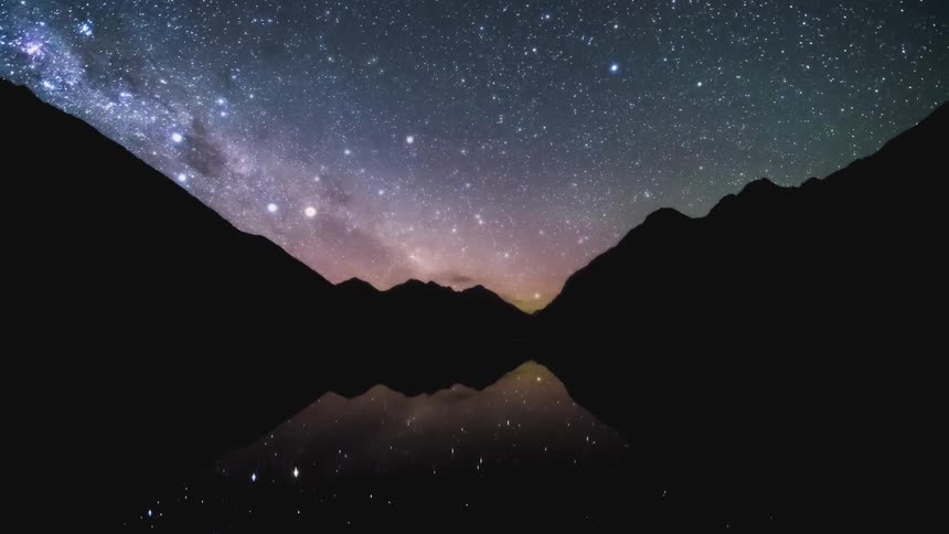 Dusk turns to night as dark clouds move over a lake in a mountain valley