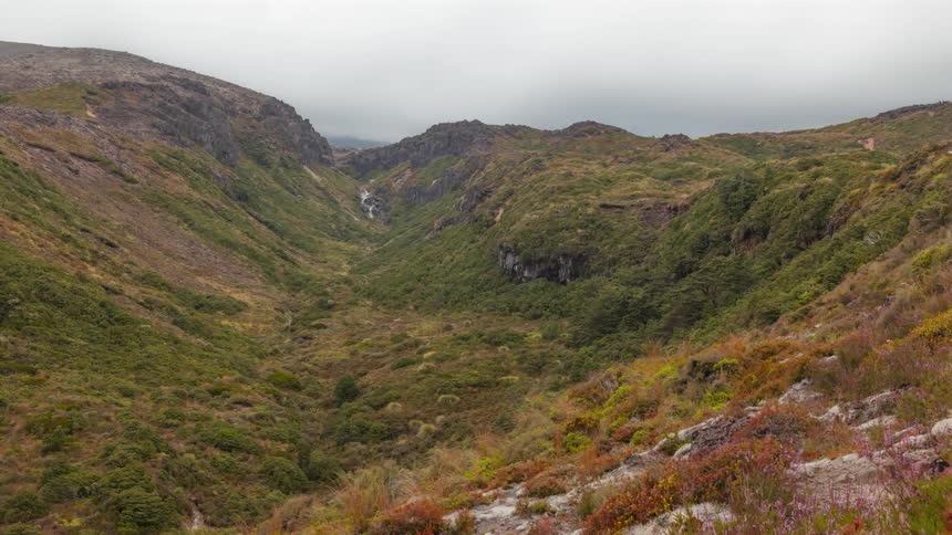 Mountainous and greenish landscape against a cloudy sky