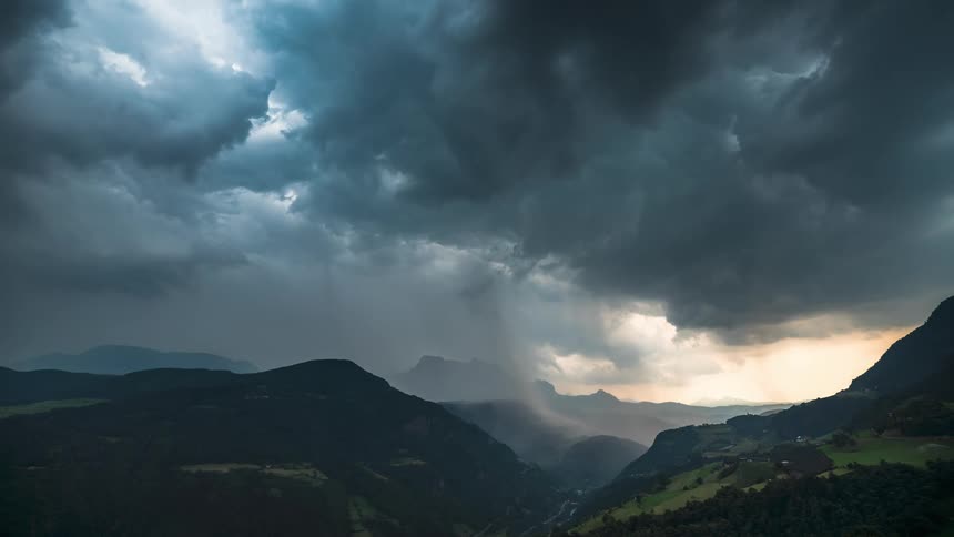 Large storm clouds move over the mountains pouring rain