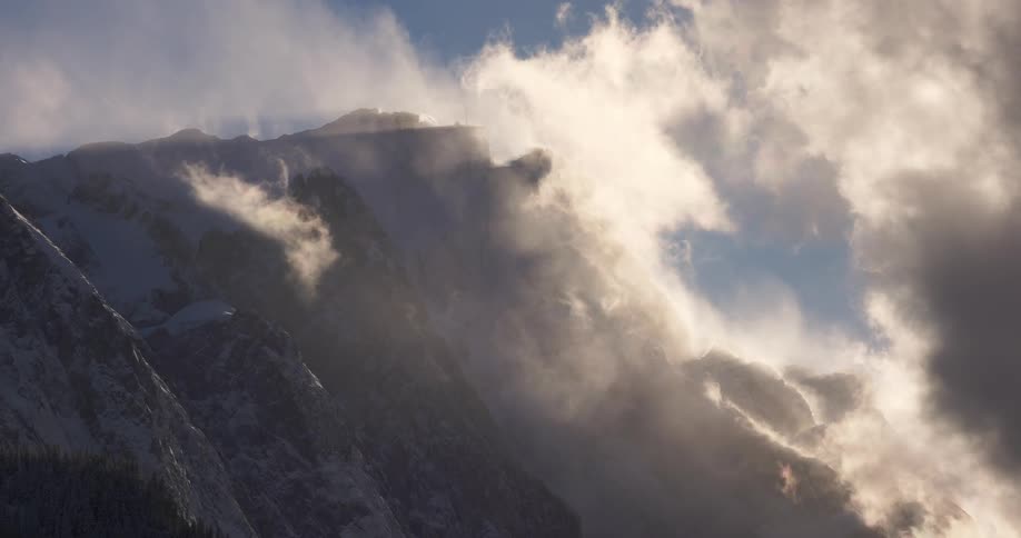Mountainous landscape covered by clouds illuminated by the sun
