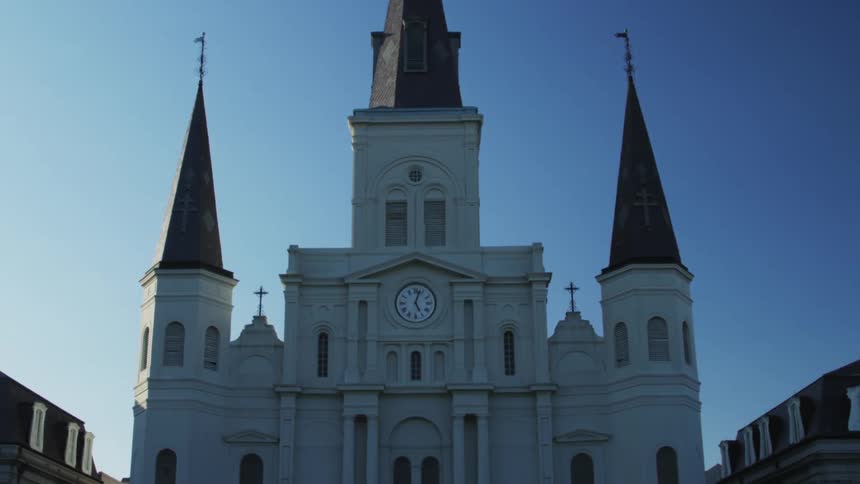 Tourists look up at an old church on a sunny day