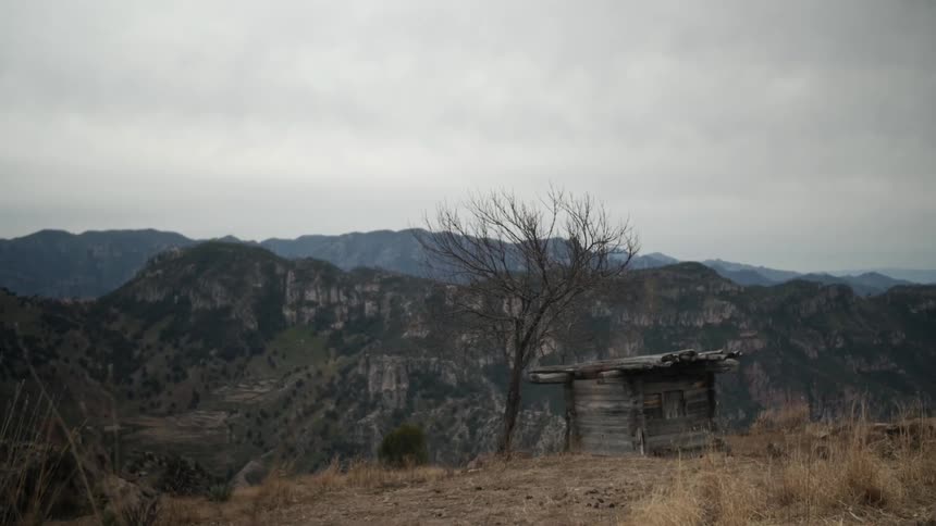 View of an abandoned small wooden building near mountains