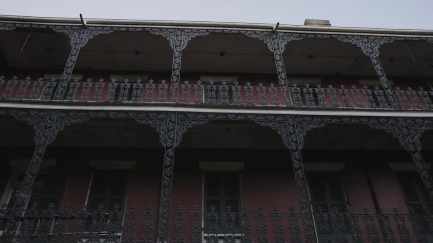 Looking up at a building with ornate hand railings and trim