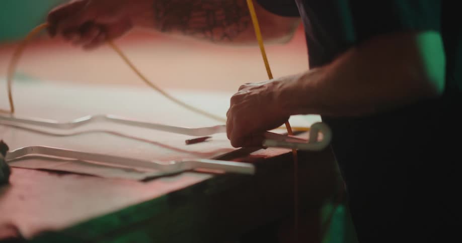 A worker arranges various tubes on a wooden desk