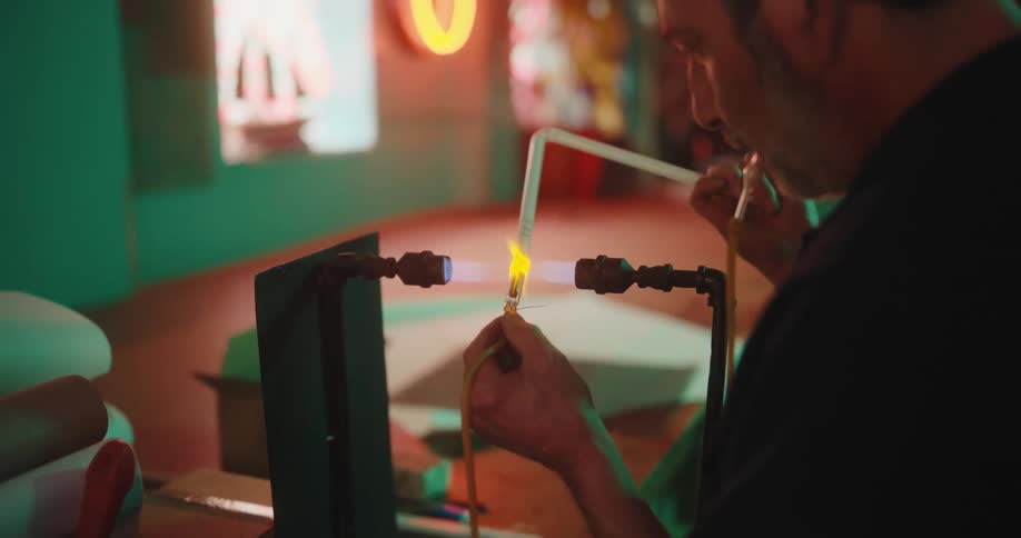 Man working with glass-blowing tools in a welding workshop