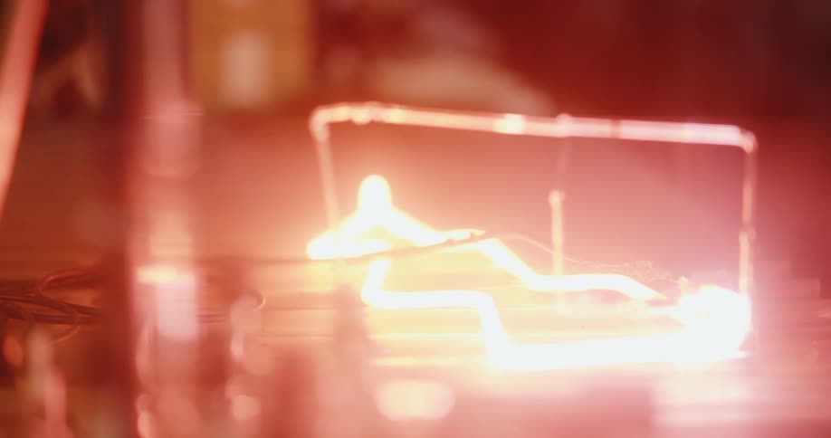 Closeup on an induction object turning on a light through a copper