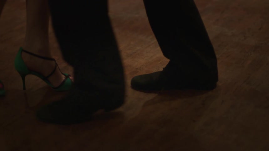 Feet of a man in green shoes and a woman in high heels dancing together