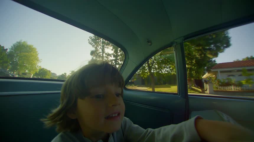 Little boy sitting inside a moving vehicle