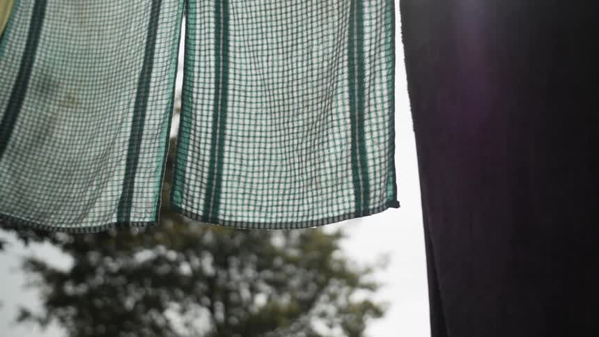 Towels wave in the breeze while hanging on a line outside