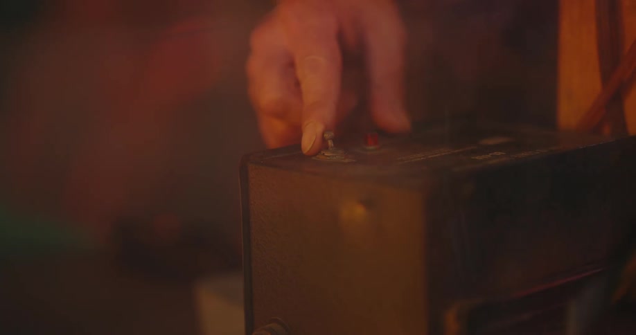A man turns a switch on a box to the on position