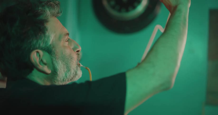 A man carefully inspects a neon light tube