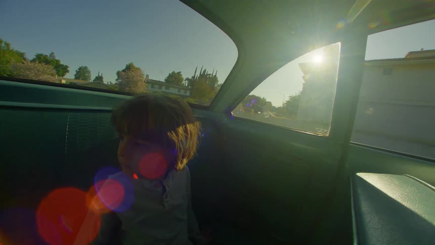 Boy sitting in the backseat of a moving car