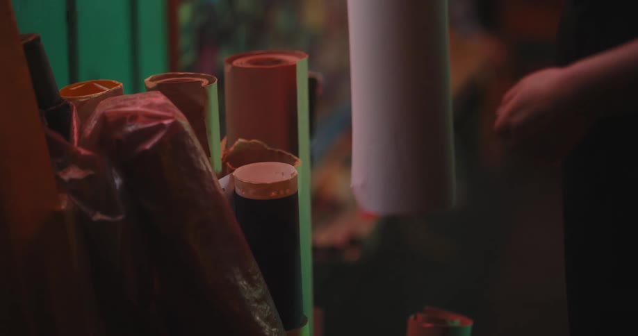 Person selects a large paper roll from a container of paper rolls