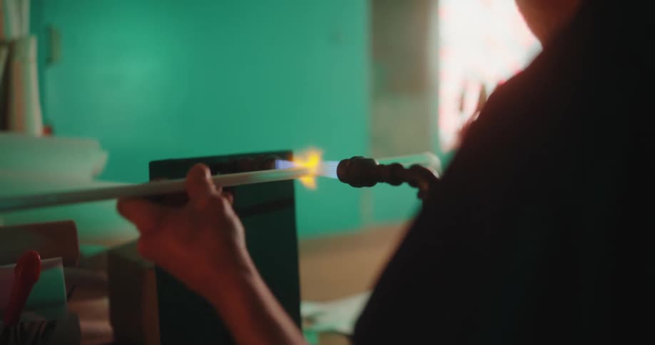 A worker uses a flame to heat a tube