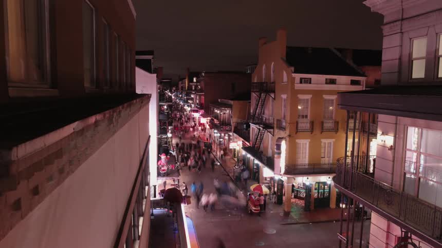 Time-lapse of people and traffic moving through a city street and intersection at night