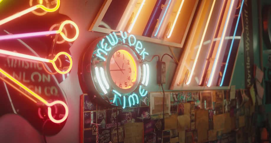 Wall in an indoor space decorated with clock and neon lights