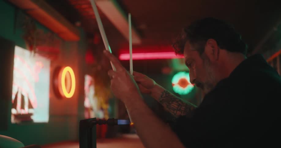 A man is blowing glass for neon signs