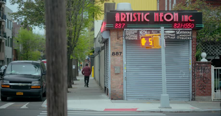 A business owner walks to the door of his business and opens it