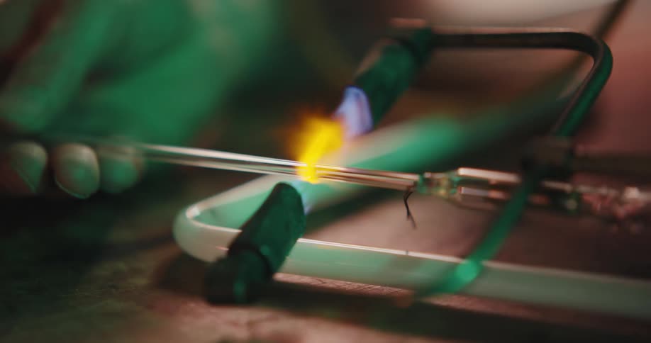 An employee heats a tube with a special hand tool