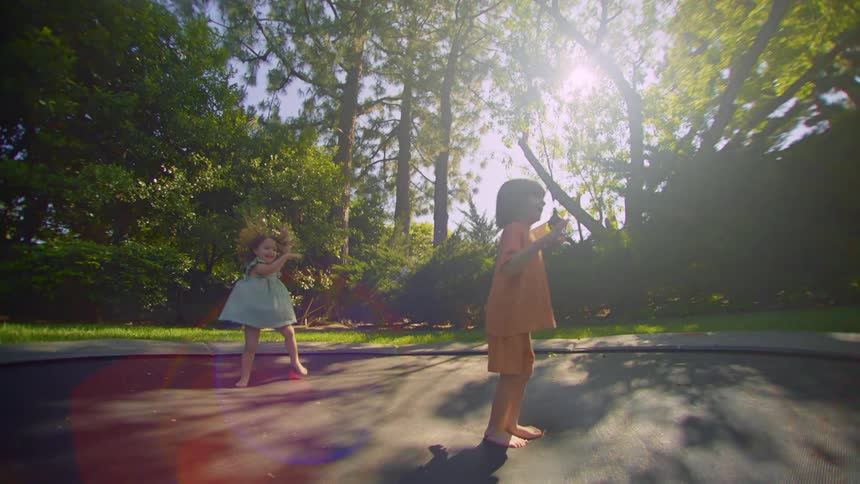 Siblings jump on the trampoline together