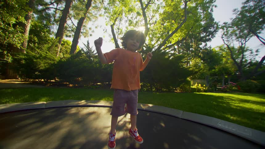 A boy is jumping on the trampoline