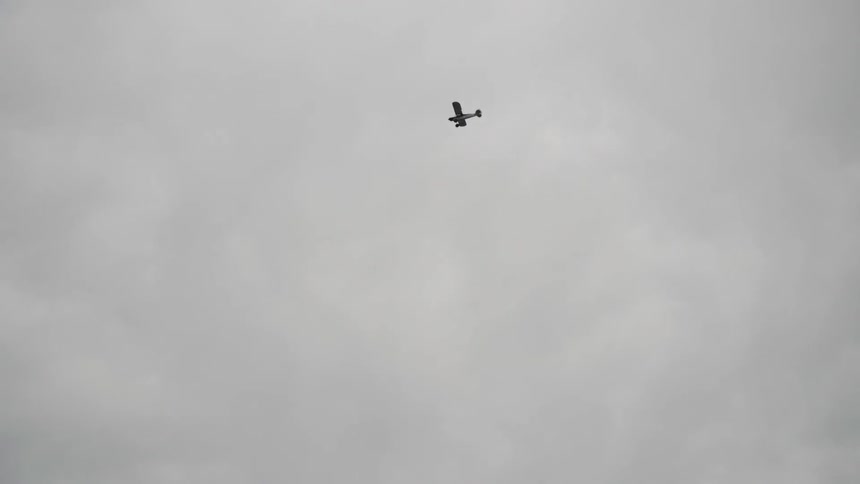 A plane flies in the sky on a cloudy day