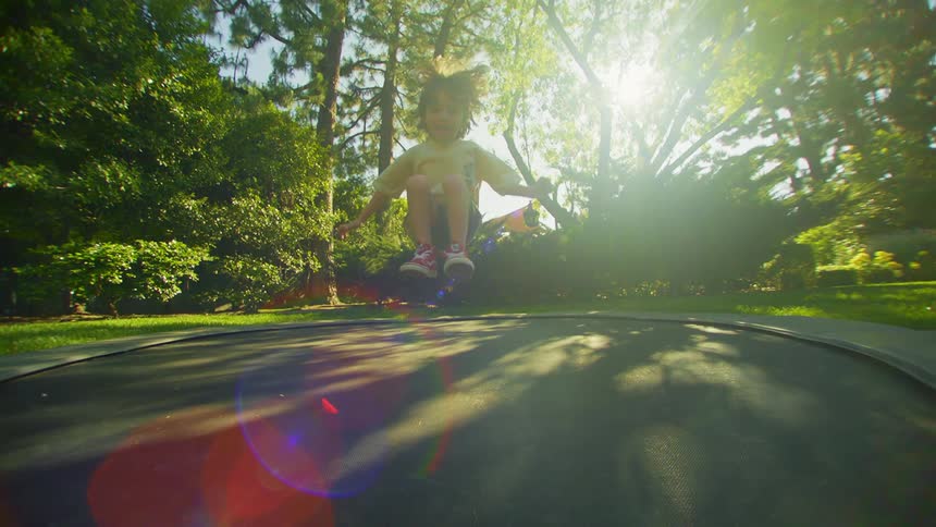 A boy jumps and falls on a ground trampoline