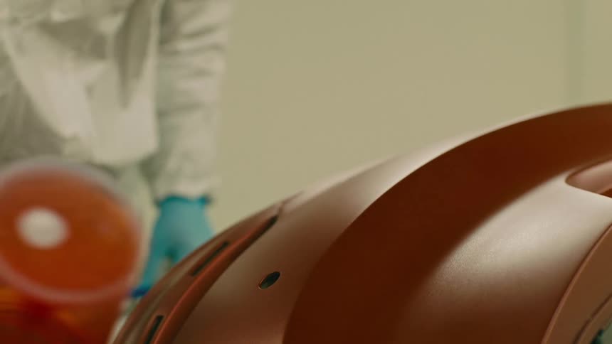A man is spray painting an object in the factory