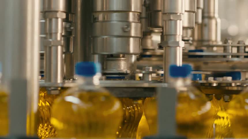 A production line filling plastic bottles with vegetable oil