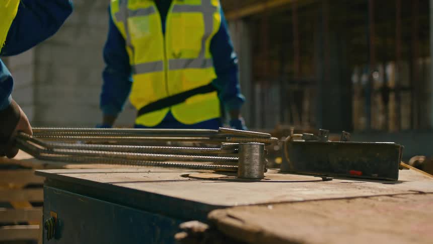 Group of men on a construction site working and sorting metals on a wooden table