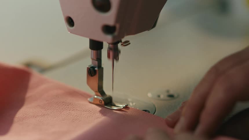 Machine sewing a pink fabric