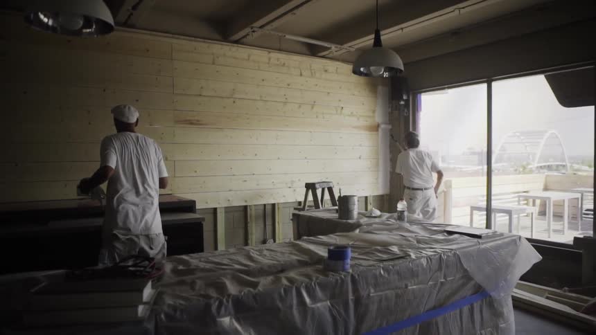 Men painting a wall in building