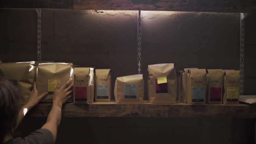 A person puts a bagged product on a shelf next to the other bags