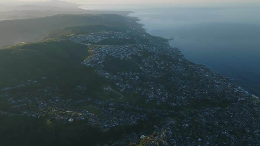 Aerial panorama of a city built amid hills by the sea