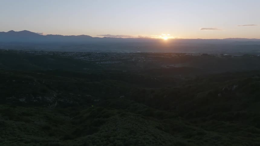 Aerial panorama of hills and mountains with sunset on the horizon