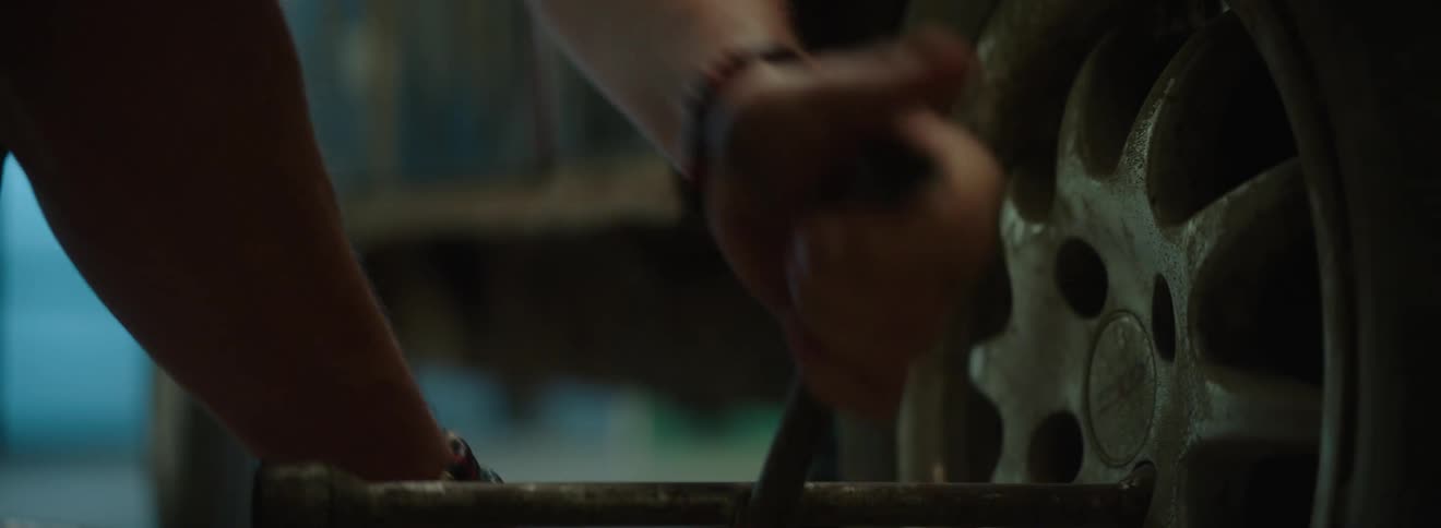 Hands of a mechanic removing wheel bolts from a vehicle