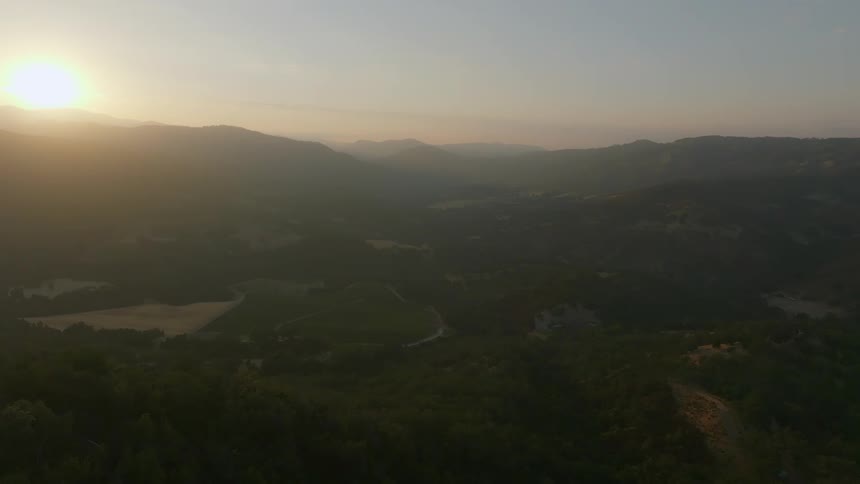 Houses sprinkle a heavily forested rural area near mountain ranges