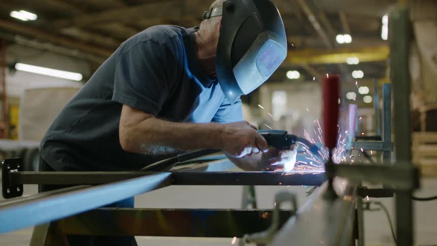 A man is welding metal with a torch