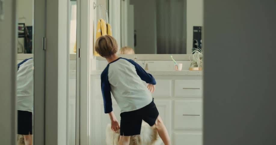 A child pulls a stool in the bathroom to use the mirror