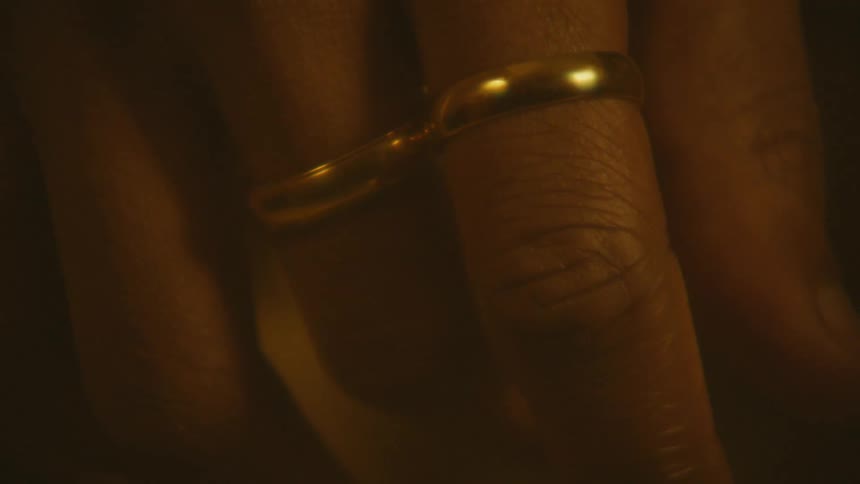 Close up of a pair of gold rings on adjacent fingers
