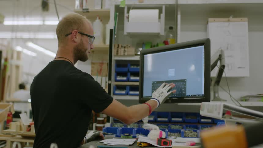 Man typing on a screen inside a factory