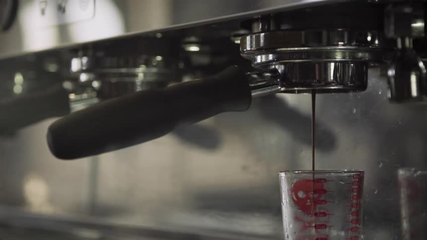 Coffee brewing and pouring into a glass container
