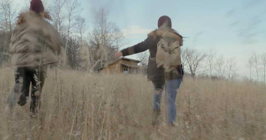 Two women run towards the small cabin