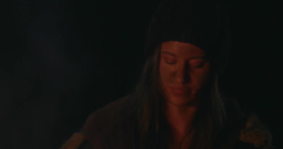 Woman outdoors at night in front of a bonfire