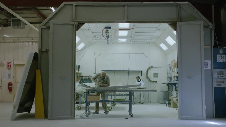 Two individuals working on a metal component