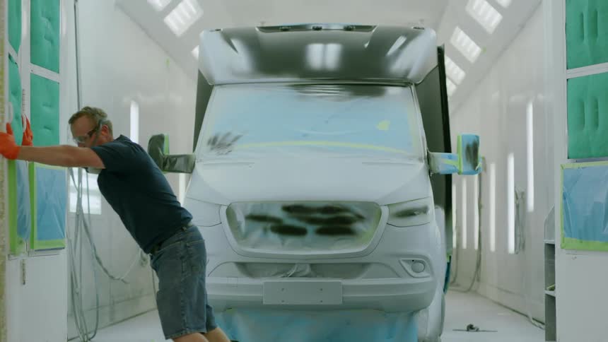 Man with protective mask and gloves opening a gate with a parked vehicle with recent paintwork