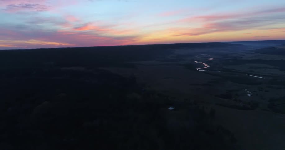 Aerial panorama of a mountainous ground against a reddish sky
