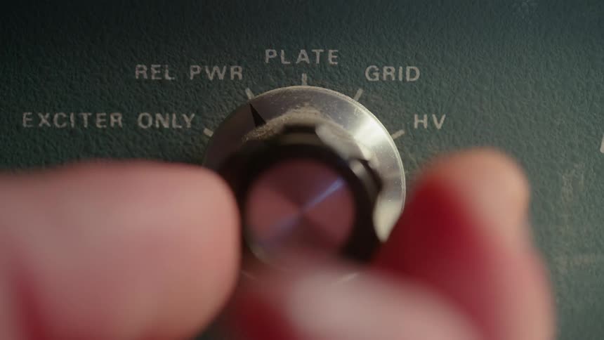 Human fingers turning a button that indicates texts written in white